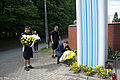 Prezydent Piotr Grzymowicz składa kwiaty przed krzyżem papieskim. Towarzyszą strażnicy miejscy
