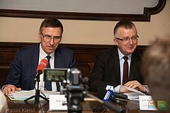 Prezydent Piotr Grzymowicz oraz przewodniczący Mirosław Gornowicz siedzą przy stole podczas konferencji