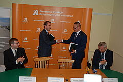 Podpisanie umowy na budowę południowej obwodnicy Olsztyna. Z lewej prezes Budimexu Dariusz Blocher, z prawej dyrektor Generalnej Dyrekcji Dróg Krajowych i Autostrad Mirosław Nicewicz - wymieniają się dokumentami.