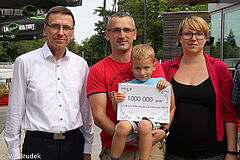 Milionowy gość CRS Ukiel w tym roku - pani Patrycja - stoi po proawej. Pośrodku jej mąż z synem na rękach, a po lewej prezydent Olsztyna Piotr Grzymowicz.