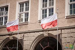 Flagi powiewające na masztach przed ratuszem