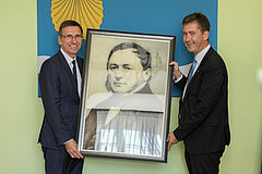 Nadburmistrz Wurzburga i prezydent Olsztyna trzymają zdjęcie dawnego burmistrza Olsztyna, jednocześnie pradziada włodarza Wurzburga