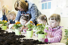 Dzieci podczas sadzenia kwiatów