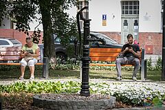 Mieszkańcy siedzą na ławkach na skwerze przy pl. Pułaskiego