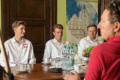 Młodzi żeglarze wraz z trenerem na spotkaniu u prezydenta Olsztyna