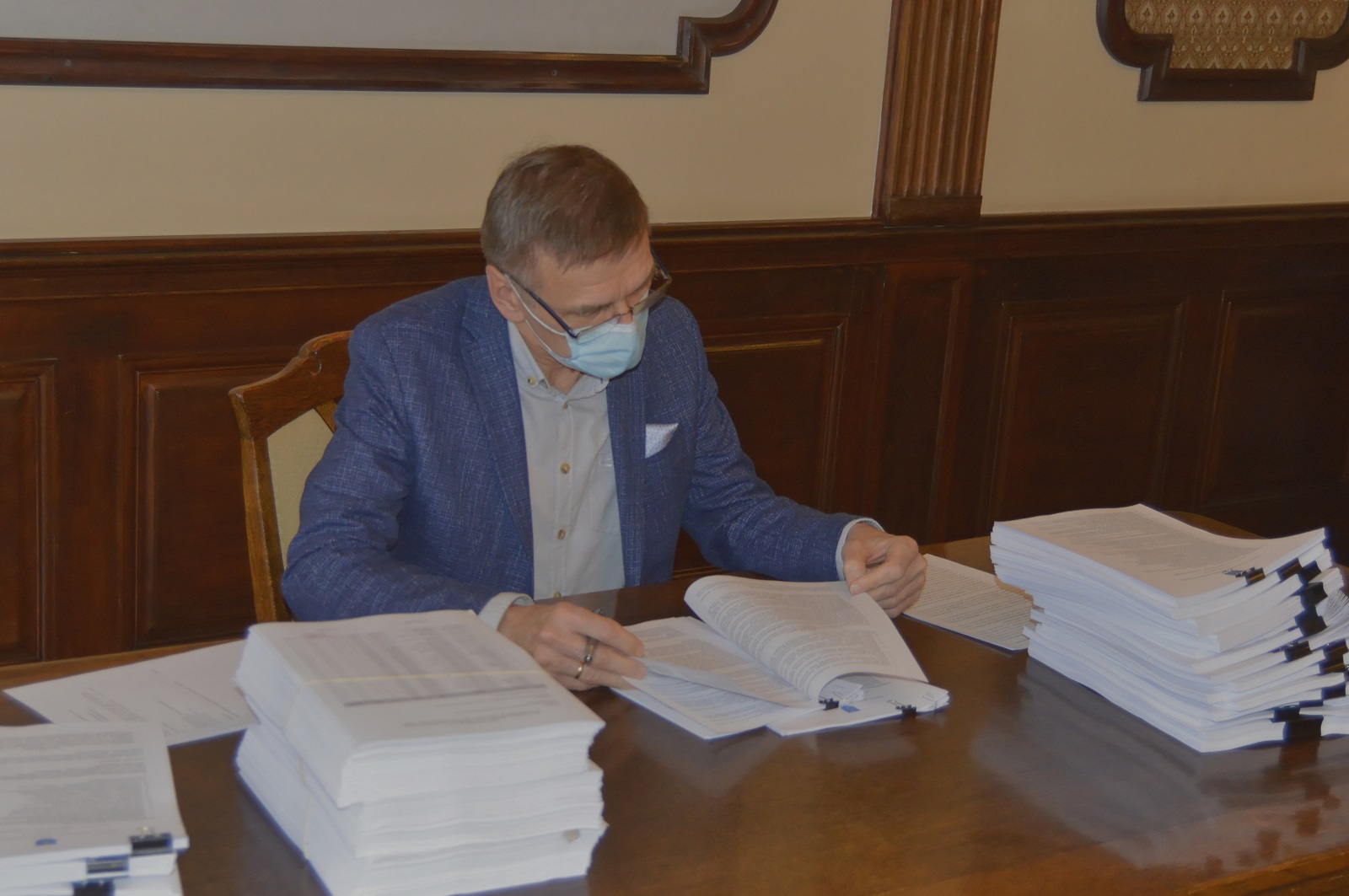 Prezydent Olsztyna podpisuje przy stole umowę